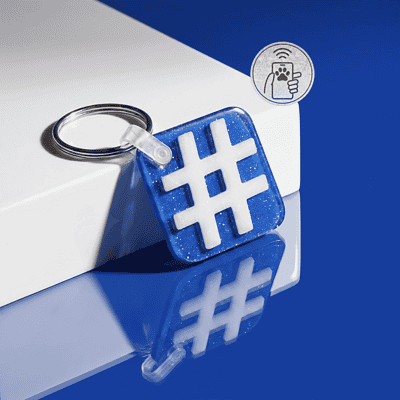 NFC pet ID tag shaped like a hashtag, designed for dogs and cats, with a keyring attachment — Shiloh's House smart NFC pet tag with free companion Lohji app.