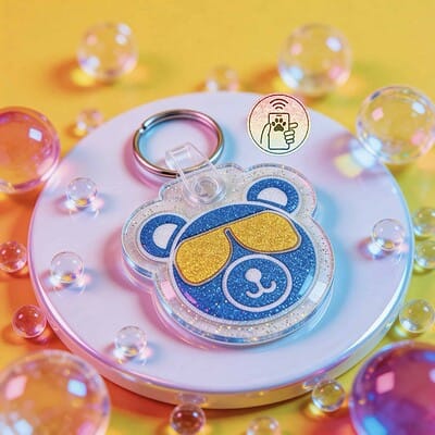 NFC pet ID tag shaped like a dog's face with glittery blue and yellow colors, surrounded by colorful.