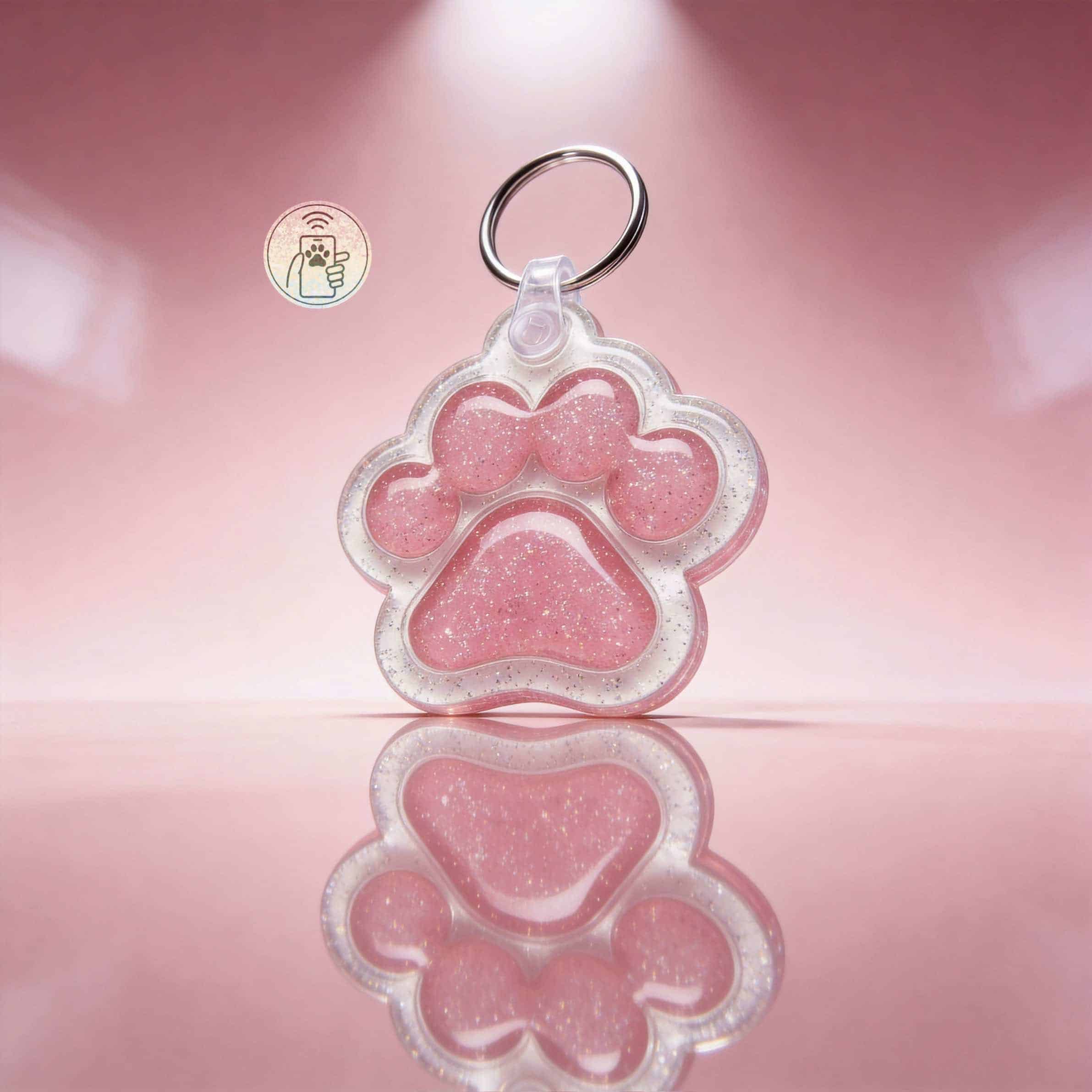 Dog or cat pet ID tag in pink glitter acrylic, shaped like a paw print with a metal ring for attachm.