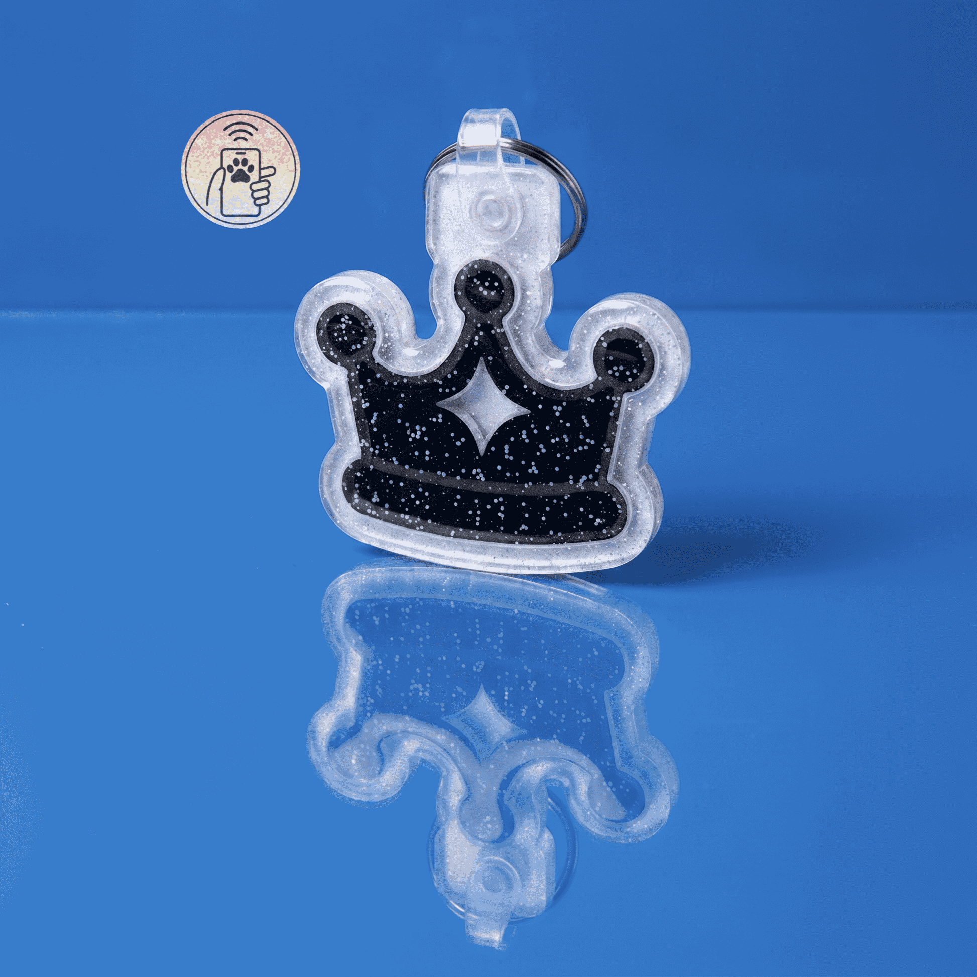 NFC-enabled pet ID tag in a clear acrylic crown shape with black glitter accents — Shiloh's House smart NFC pet tag with free companion Lohji app.