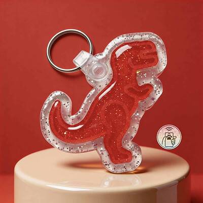 Clear glitter dinosaur-shaped NFC pet ID tag with red interior on a beige surface.