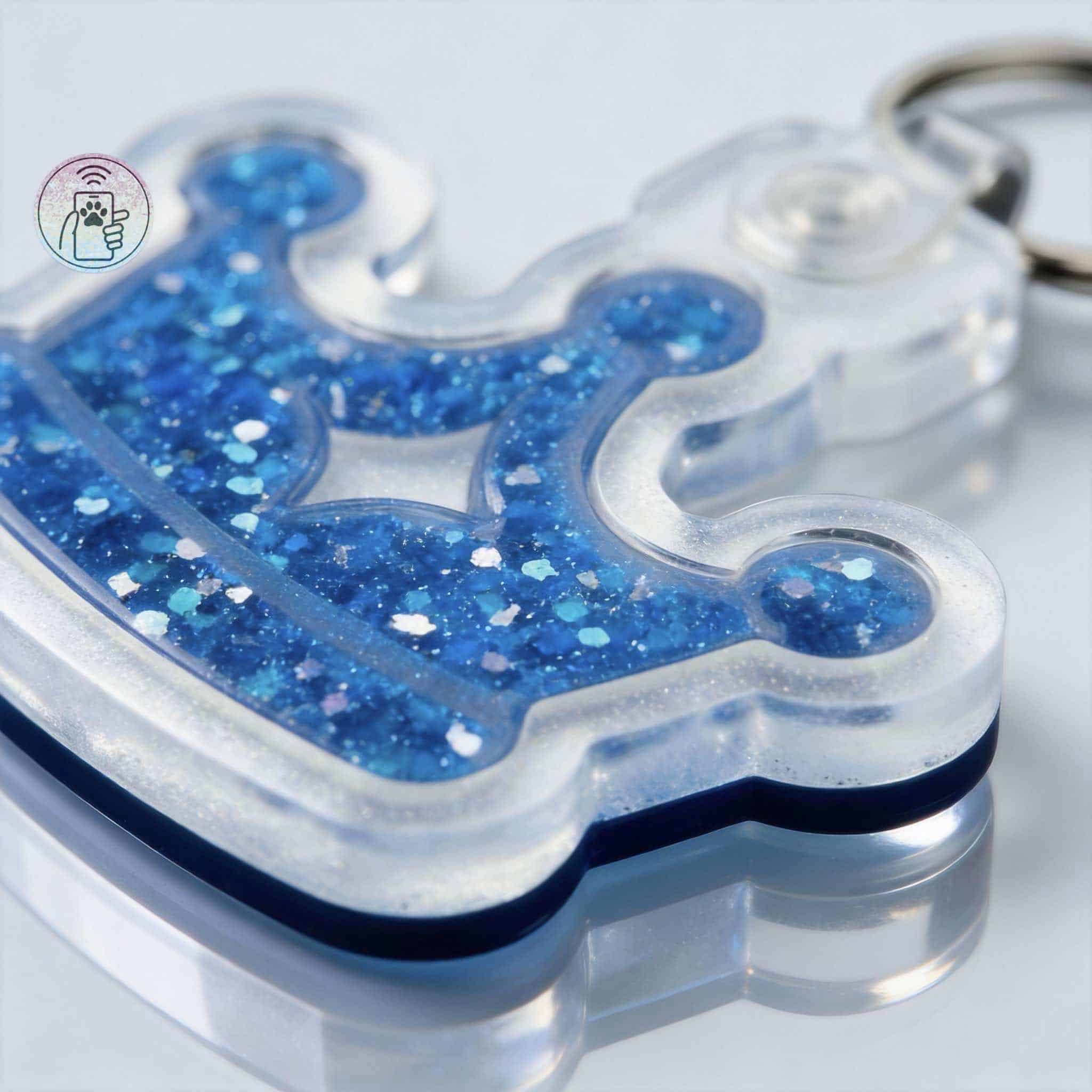 Blue glitter pet ID tag in a clear acrylic shape with a keyring for dogs and cats — Shiloh's House smart NFC pet tag with free companion Lohji app.