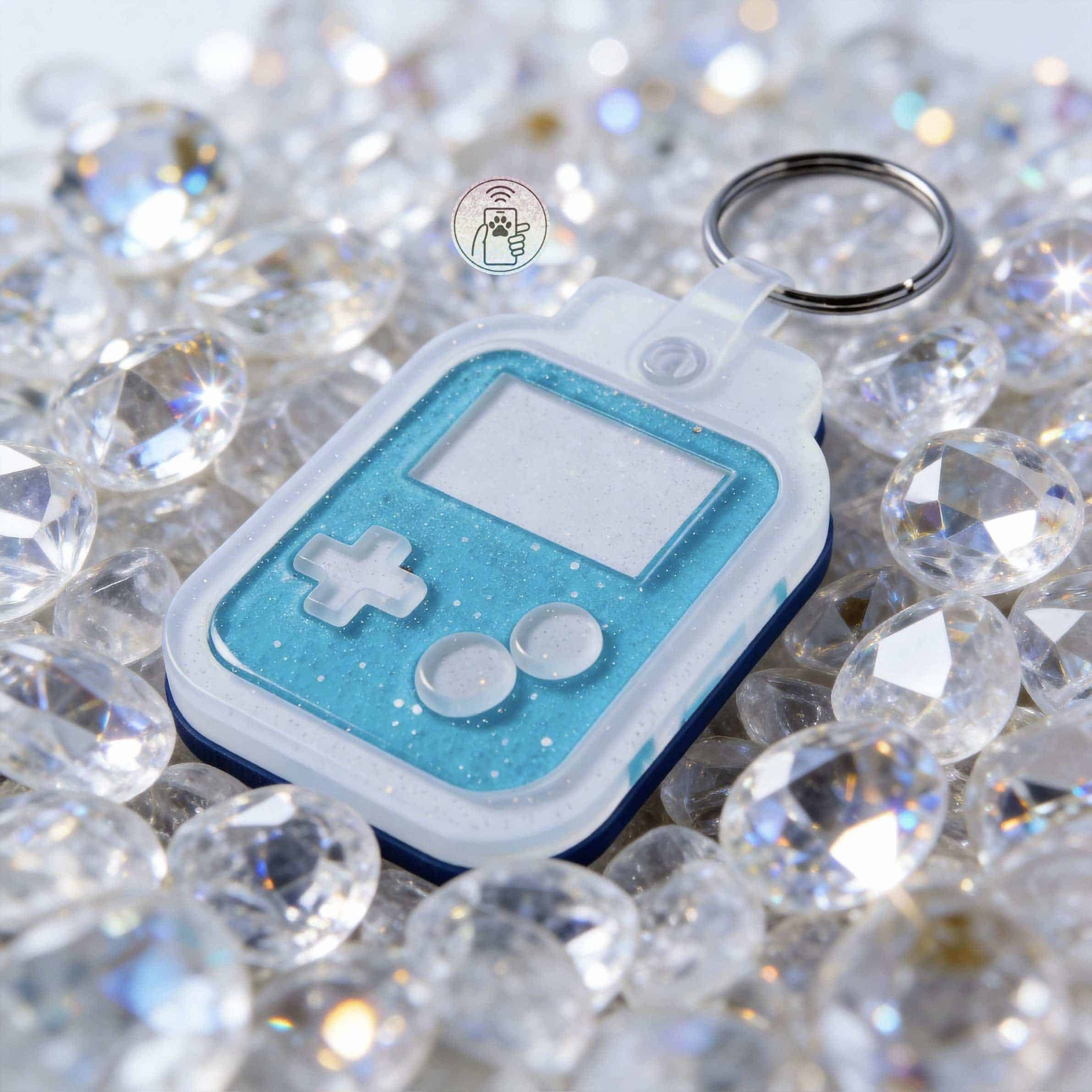 NFC pet ID tag shaped like a retro handheld game with sparkly blue details, ideal for dogs and cats, — Shiloh's House smart NFC pet tag with free companion Lohji app.