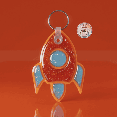 NFC pet ID tag shaped like a rocket, perfect for dogs and cats, with bright orange and blue acrylic — Shiloh's House smart NFC pet tag with free companion Lohji app.