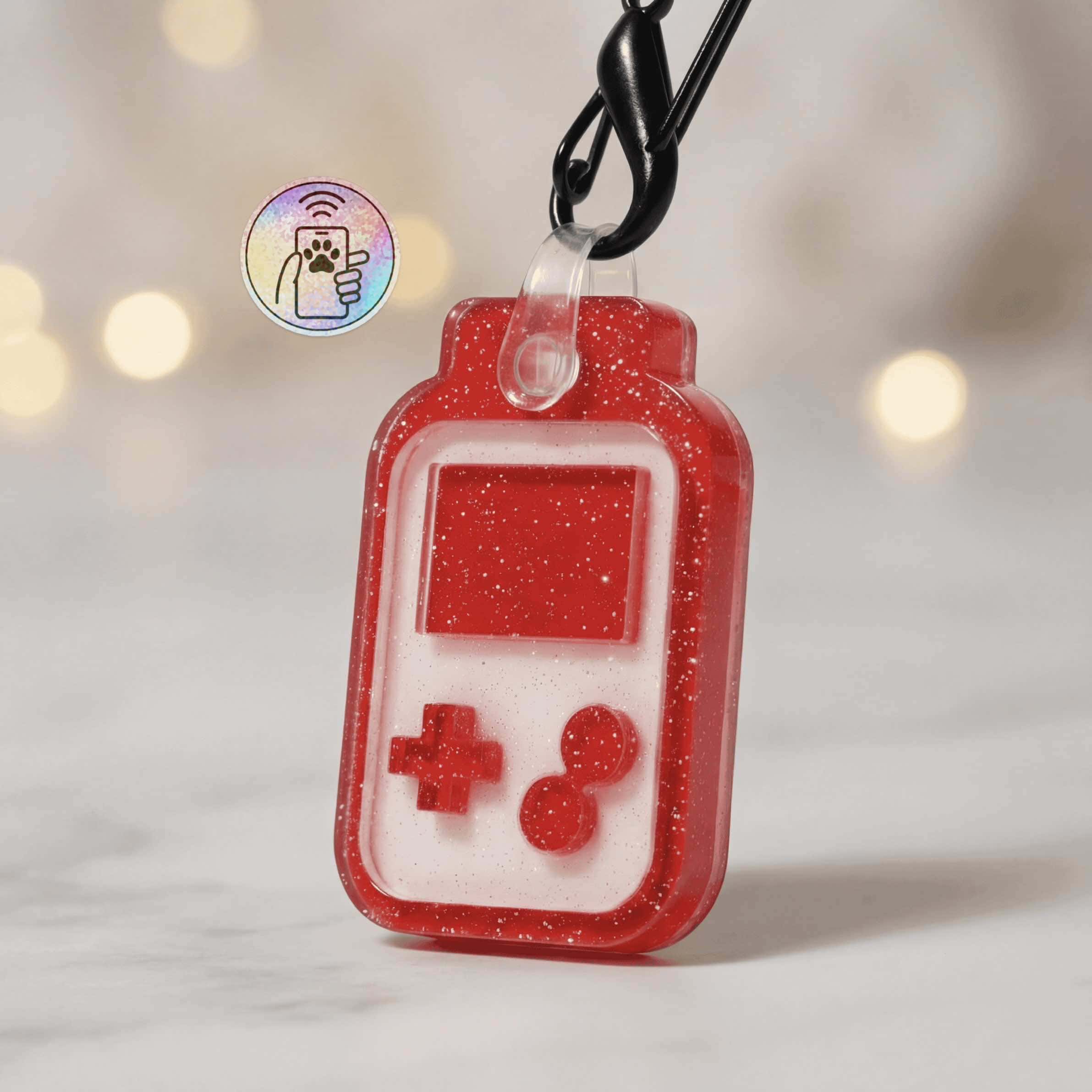 NFC-enabled pet ID tag shaped like a handheld gaming device with red glitter finish.