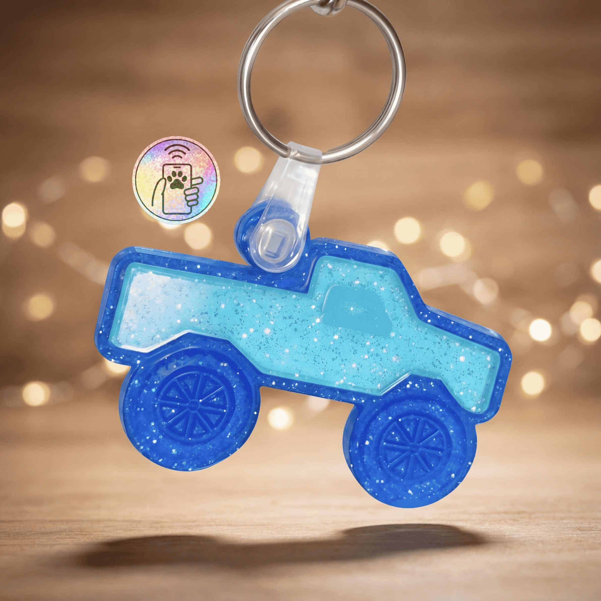 Bright blue truck-shaped NFC pet ID tag with glowing LED lights and keyring attachment.