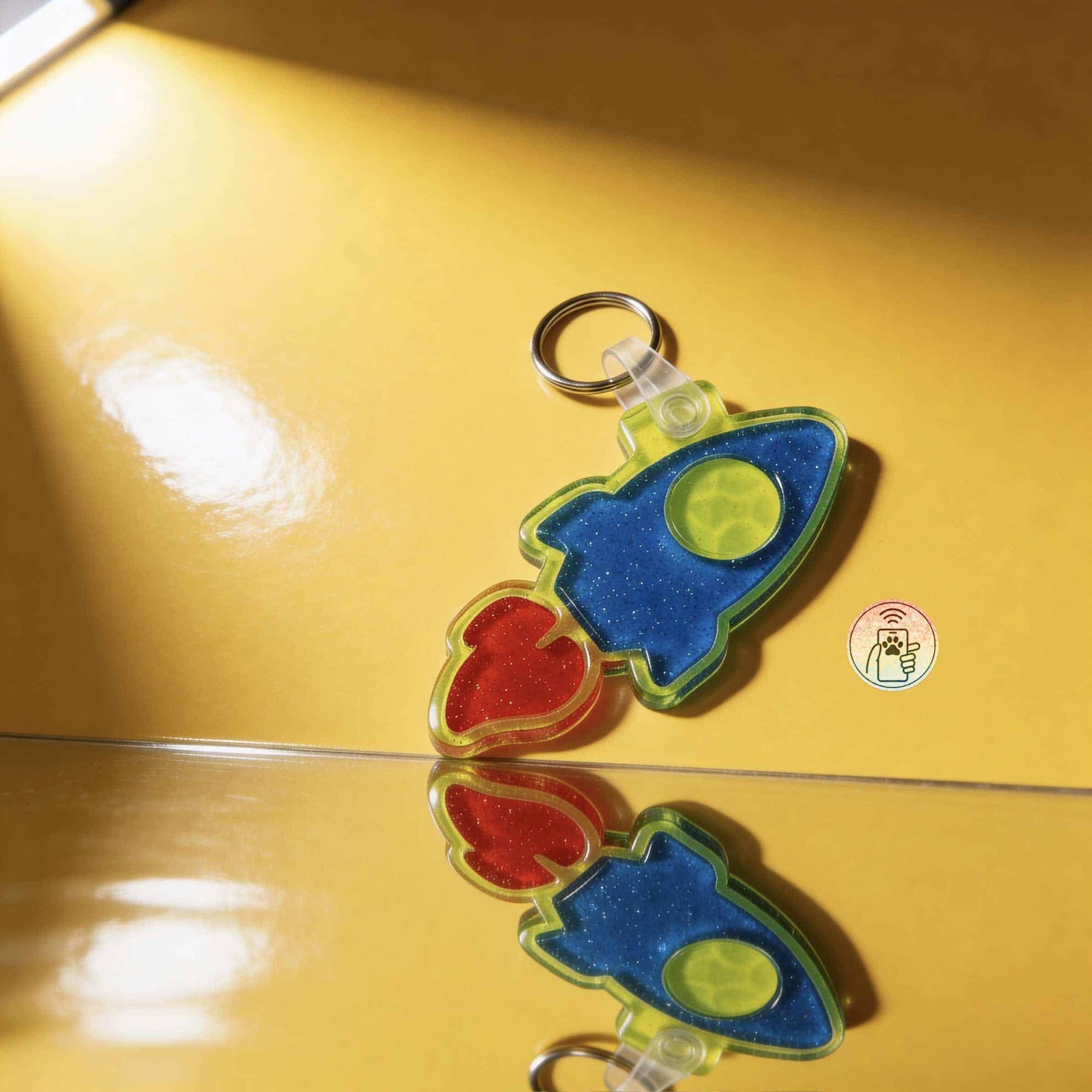 NFC pet ID tag shaped like a rocket with vibrant colors for dogs and cats.