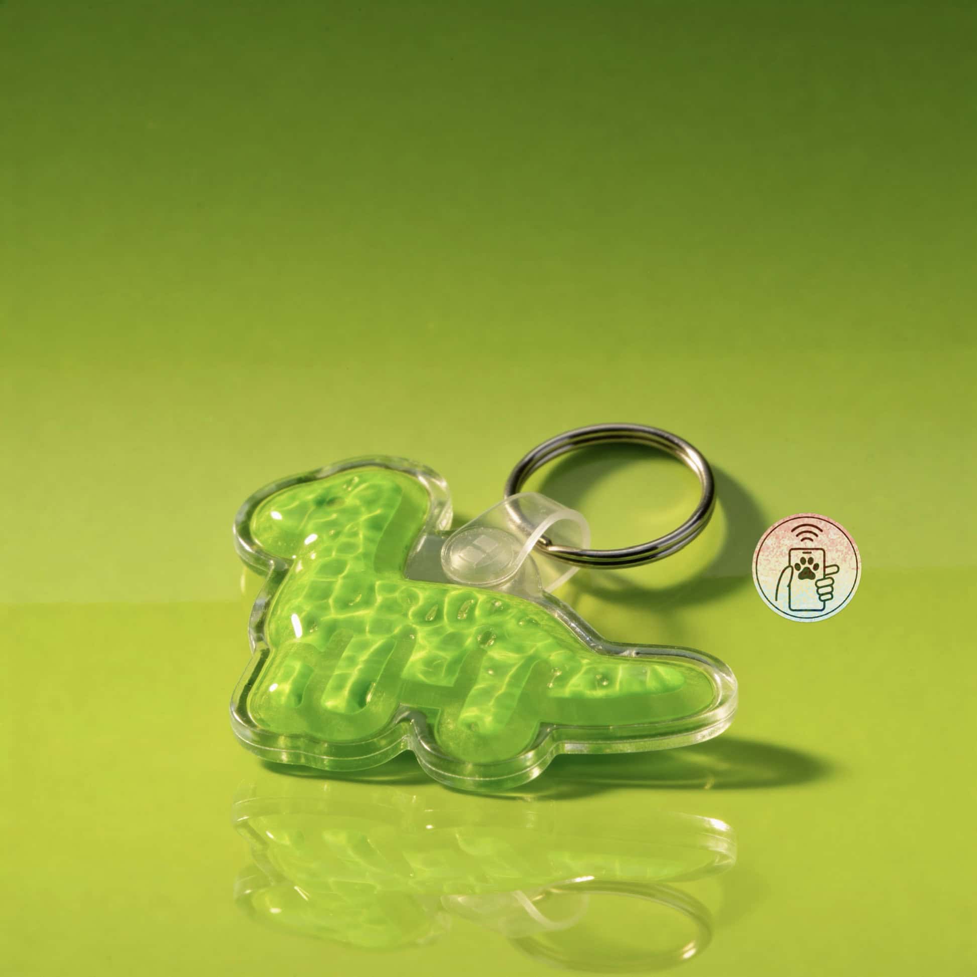 NFC pet ID tag shaped like a dinosaur, made of bright green acrylic, with a keyring attachment.